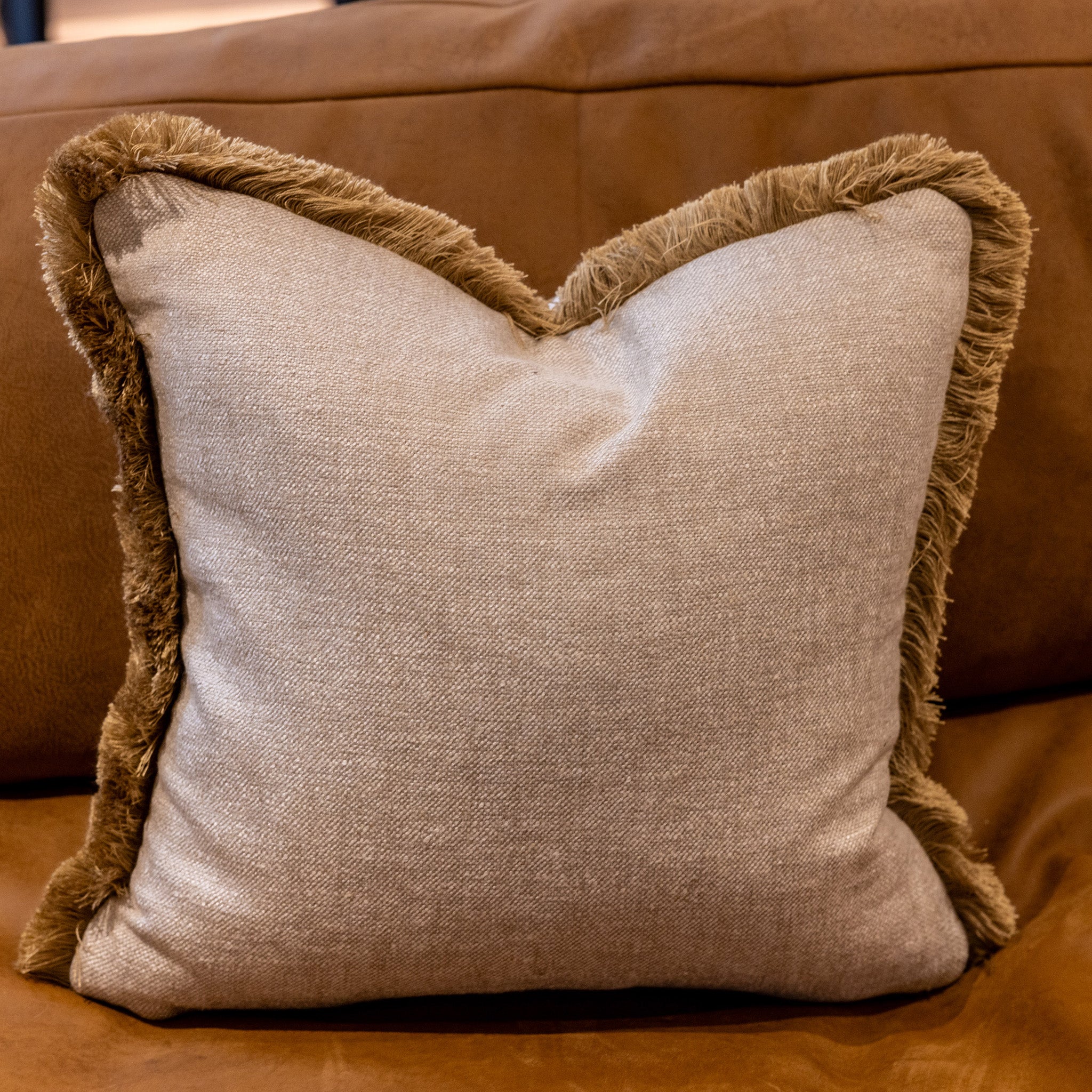 Luxury fringed cushion in a linen mix fabric in a defined oatmeal coloured weave, with russett coloured brushed fringe trim. A plump feather inner cushion included. Our made to order cushions are plump and cosy. Dimensions: 500 x 500 mm Made to order in approx 3 weeks